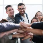 young business group putting palms together
