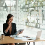 Professional woman at a desk working on sales recruitment and talent acquisition.