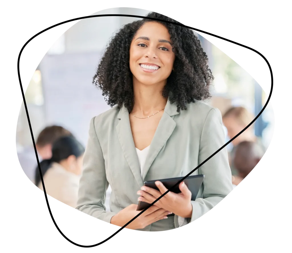 Smiling professional woman holding a tablet in an office setting, representing recruitment and talent.