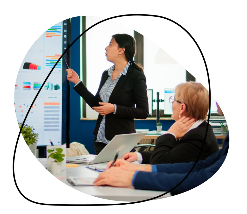 Professional presenting sales and marketing data to executives in a meeting.