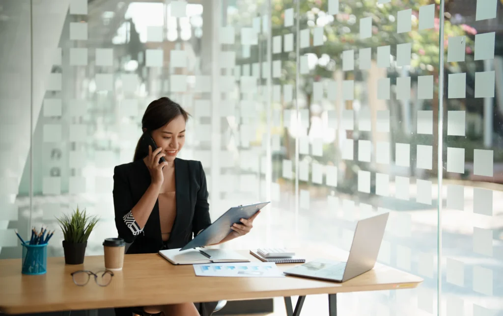 Professional woman at a desk working on sales recruitment and talent acquisition.