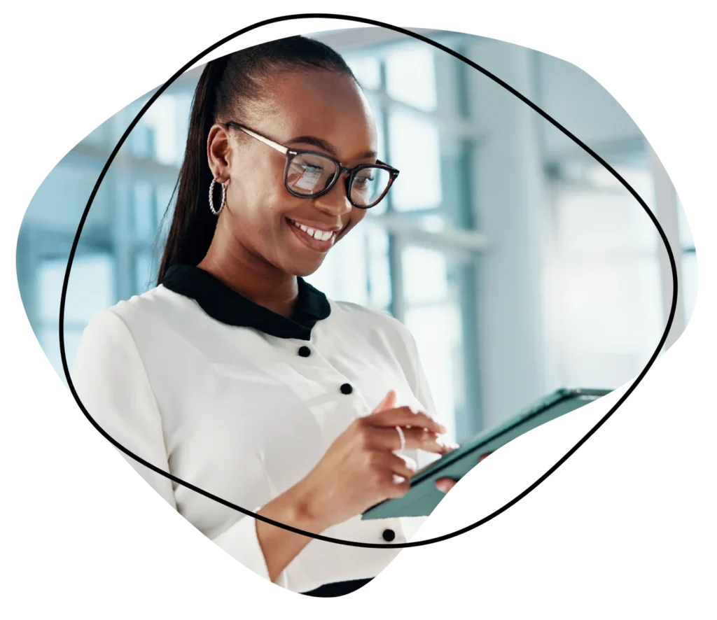 Professional woman smiling while using a tablet, representing sales and marketing talent recruitment.